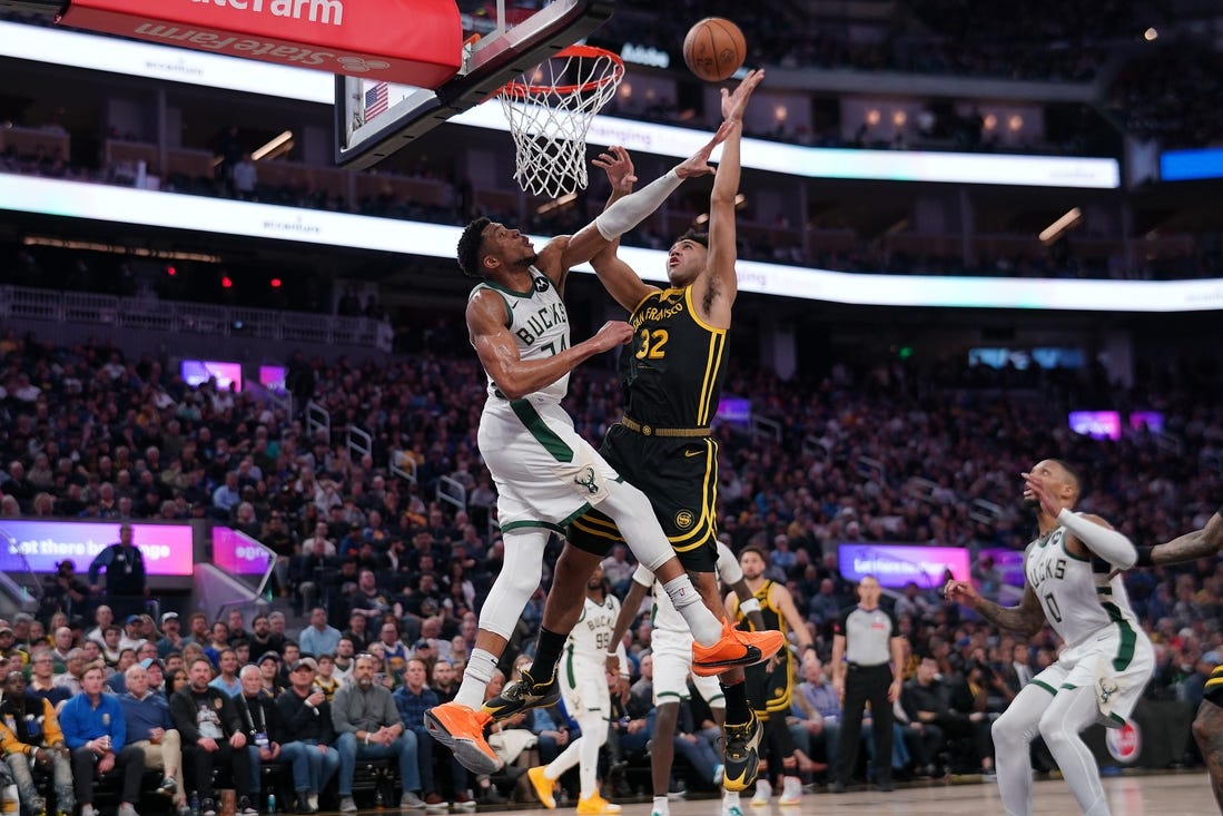 Mar 6, 2024; San Francisco, California, USA; Golden State Warriors forward Trayce Jackson-Davis (32) makes a shot over Milwaukee Bucks forward Giannis Antetokounmpo (34) in the third quarter at the Chase Center. Mandatory Credit: Cary Edmondson-USA TODAY Sports