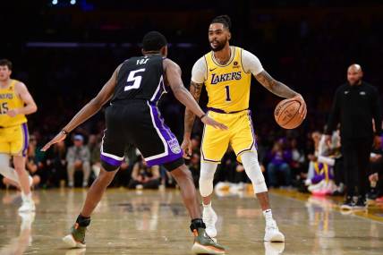 Mar 6, 2024; Los Angeles, California, USA; Los Angeles Lakers guard D'Angelo Russell (1) controls the ball against Sacramento Kings guard De'Aaron Fox (5) during the second half at Crypto.com Arena. Mandatory Credit: Gary A. Vasquez-USA TODAY Sports