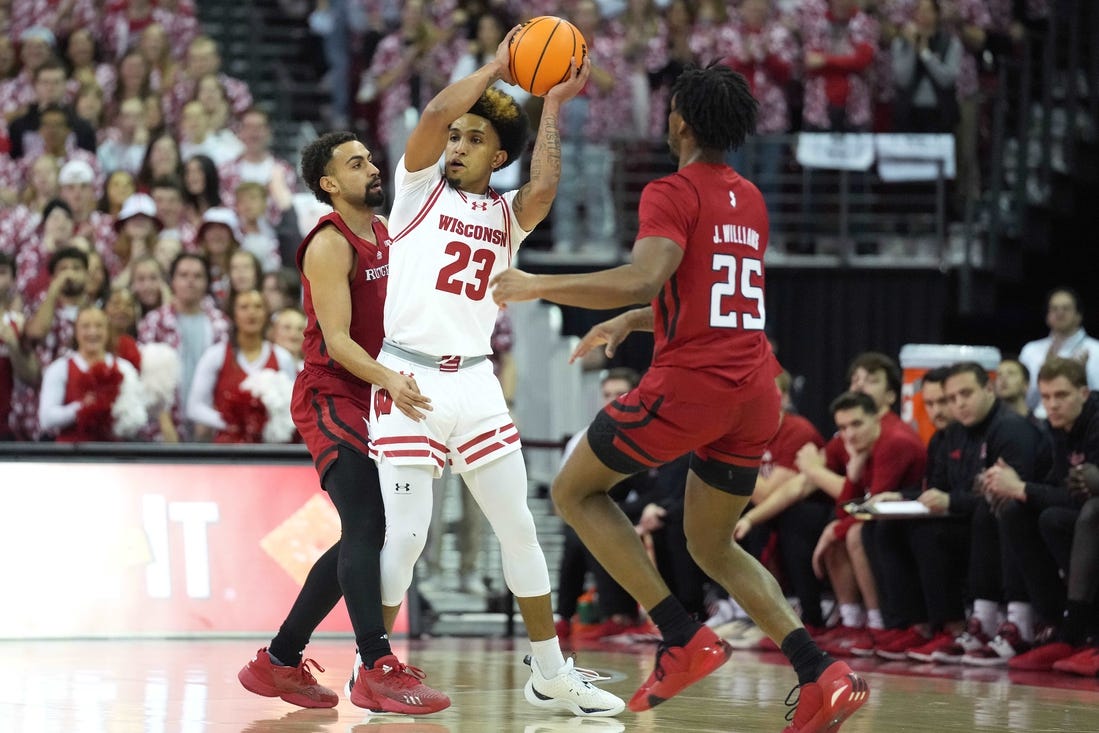 Mar 7, 2024; Madison, Wisconsin, USA;  Wisconsin Badgers guard Chucky Hepburn (23) looks to pass the ball against Rutgers Scarlet Knights guard Noah Fernandes (2) and Rutgers Scarlet Knights guard Jeremiah Williams (25) during the first half at Kohl Center. Mandatory Credit: Kayla Wolf-USA TODAY Sports