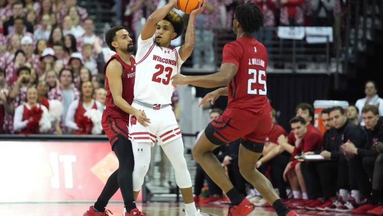 Mar 7, 2024; Madison, Wisconsin, USA;  Wisconsin Badgers guard Chucky Hepburn (23) looks to pass the ball against Rutgers Scarlet Knights guard Noah Fernandes (2) and Rutgers Scarlet Knights guard Jeremiah Williams (25) during the first half at Kohl Center. Mandatory Credit: Kayla Wolf-USA TODAY Sports