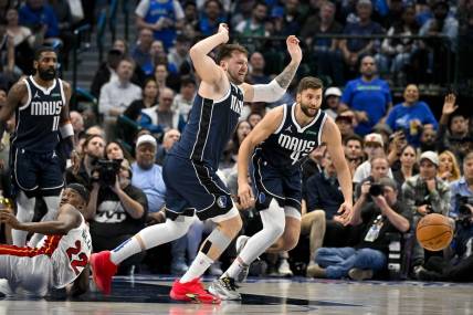 Mar 7, 2024; Dallas, Texas, USA; Dallas Mavericks guard Luka Doncic (77) and forward Maxi Kleber (42) chase the loose ball during the second half against the Miami Heat at the American Airlines Center. Mandatory Credit: Jerome Miron-USA TODAY Sports