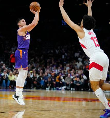 Suns guard Grayson Allen (8) makes a three pointer against Raptors forward Jordan Nwora (13) during a game at the Footprint Center.