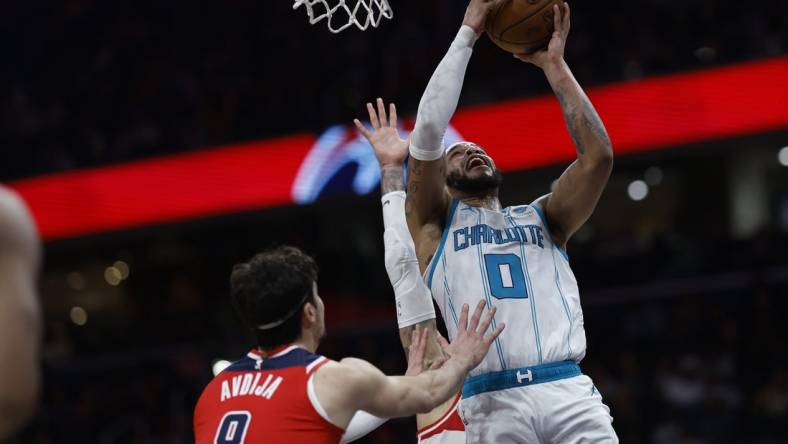 Mar 8, 2024; Washington, District of Columbia, USA; Charlotte Hornets forward Miles Bridges (0) shoots the ball as Washington Wizards forward Kyle Kuzma (33) and Wizards forward Deni Avdija (8) defend in the second half at Capital One Arena. Mandatory Credit: Geoff Burke-USA TODAY Sports