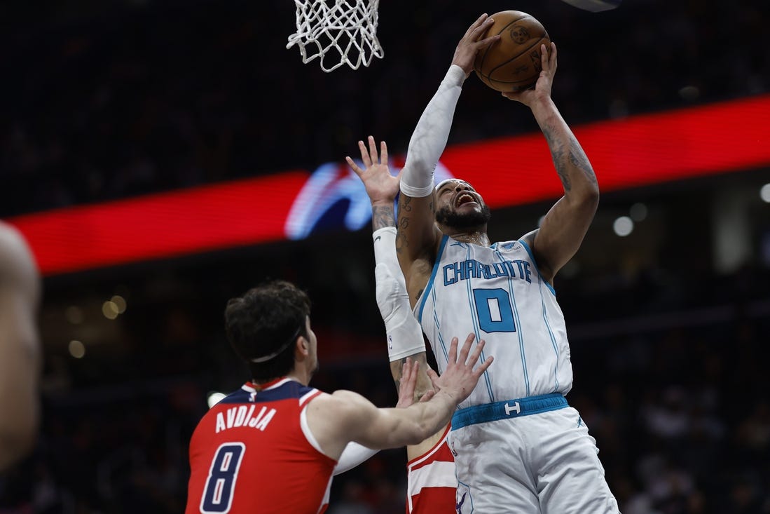 Mar 8, 2024; Washington, District of Columbia, USA; Charlotte Hornets forward Miles Bridges (0) shoots the ball as Washington Wizards forward Kyle Kuzma (33) and Wizards forward Deni Avdija (8) defend in the second half at Capital One Arena. Mandatory Credit: Geoff Burke-USA TODAY Sports