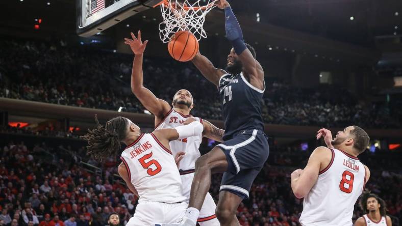 Mar 9, 2024; New York, New York, USA;  Georgetown Hoyas forward Supreme Cook (24) dunks past St. John's Red Storm guard Daniss Jenkins (5) in the first half at Madison Square Garden. Mandatory Credit: Wendell Cruz-USA TODAY Sports