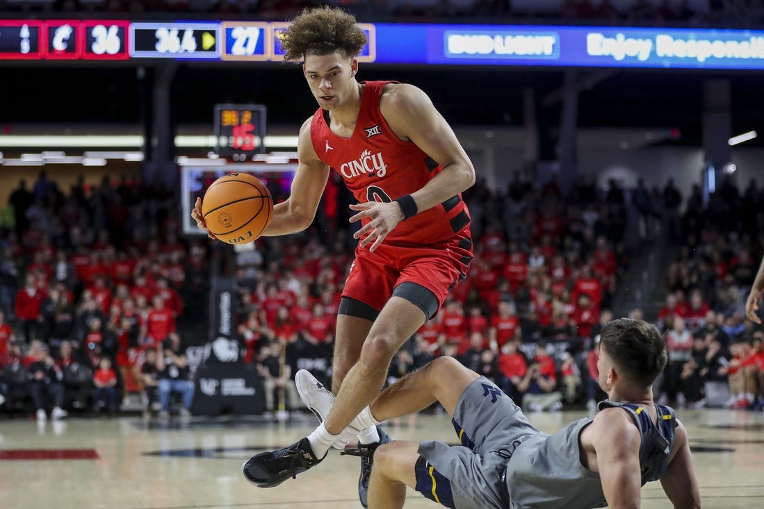 Mar 9, 2024; Cincinnati, Ohio, USA; Cincinnati Bearcats guard Dan Skillings Jr. (0) drives to the basket against West Virginia Mountaineers guard Kerr Kriisa (3) in the first half at Fifth Third Arena. Mandatory Credit: Katie Stratman-USA TODAY Sports