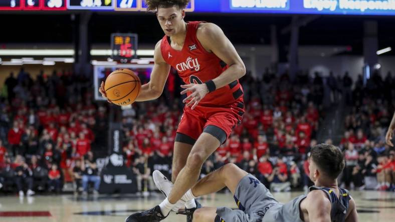 Mar 9, 2024; Cincinnati, Ohio, USA; Cincinnati Bearcats guard Dan Skillings Jr. (0) drives to the basket against West Virginia Mountaineers guard Kerr Kriisa (3) in the first half at Fifth Third Arena. Mandatory Credit: Katie Stratman-USA TODAY Sports