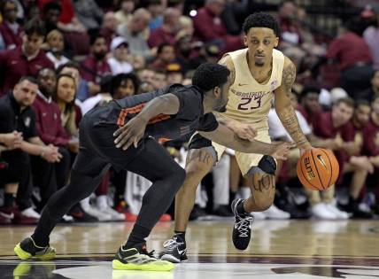 Mar 9, 2024; Tallahassee, Florida, USA; Florida State Seminoles guard Primo Spears (23) controls the ball against Miami Hurricanes guard Bensley Joseph (4) during the first half at Donald L. Tucker Center. Mandatory Credit: Melina Myers-USA TODAY Sports