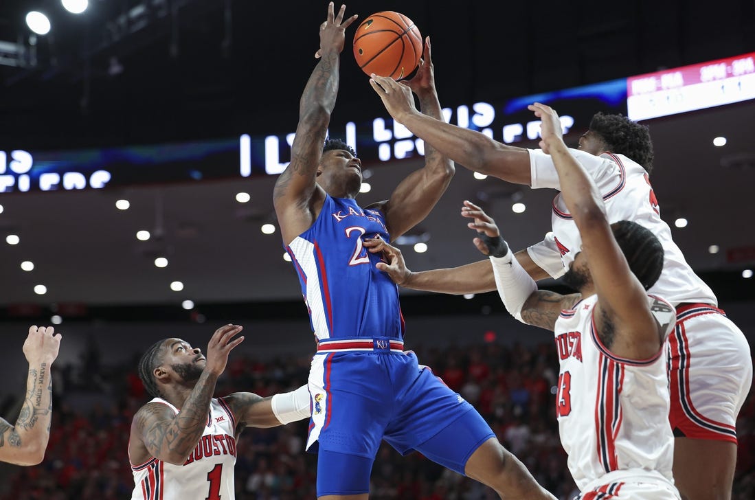 Mar 9, 2024; Houston, Texas, USA; Kansas Jayhawks forward K.J. Adams Jr. (24) attempts to control the ball as Houston Cougars center Cedric Lath (2) defends during the first half at Fertitta Center. Mandatory Credit: Troy Taormina-USA TODAY Sports