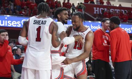 Mar 9, 2024; Houston, Texas, USA; Houston Cougars forward J'Wan Roberts (13) celebrates with guard Mylik Wilson (8) and guard Jamal Shead (1) in the final minute of the game against the Kansas Jayhawks at Fertitta Center. Mandatory Credit: Troy Taormina-USA TODAY Sports