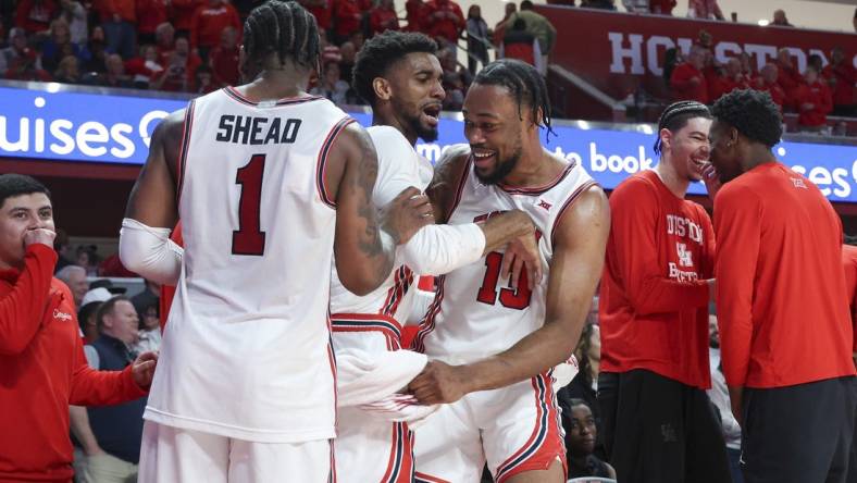 Mar 9, 2024; Houston, Texas, USA; Houston Cougars forward J'Wan Roberts (13) celebrates with guard Mylik Wilson (8) and guard Jamal Shead (1) in the final minute of the game against the Kansas Jayhawks at Fertitta Center. Mandatory Credit: Troy Taormina-USA TODAY Sports