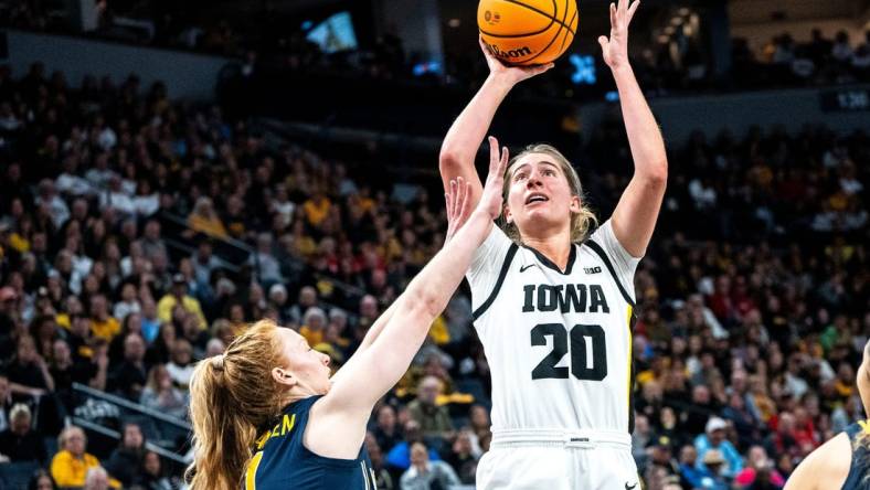 Iowa guard Kate Martin (20) attempts a shot against Michigan guard Lauren Hansen (1) during the Big Ten Tournament semifinals at the Target Center on Saturday, March 9, 2024, in Minneapolis, Minn.