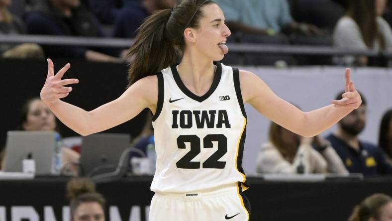 Mar 9, 2024; Minneapolis, MN, USA;  Iowa Hawkeyes guard Caitlin Clark (22) celebrates a three-pointer just inside the half-court line Michigan Wolverines during the first half of the Big Ten Women's Basketball tournament semifinal at Target Center. Mandatory Credit: Nick Wosika-USA TODAY Sports