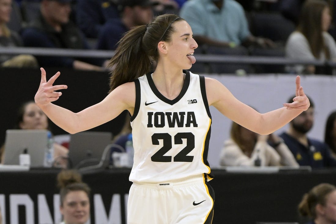 Mar 9, 2024; Minneapolis, MN, USA;  Iowa Hawkeyes guard Caitlin Clark (22) celebrates a three-pointer just inside the half-court line Michigan Wolverines during the first half of the Big Ten Women's Basketball tournament semifinal at Target Center. Mandatory Credit: Nick Wosika-USA TODAY Sports