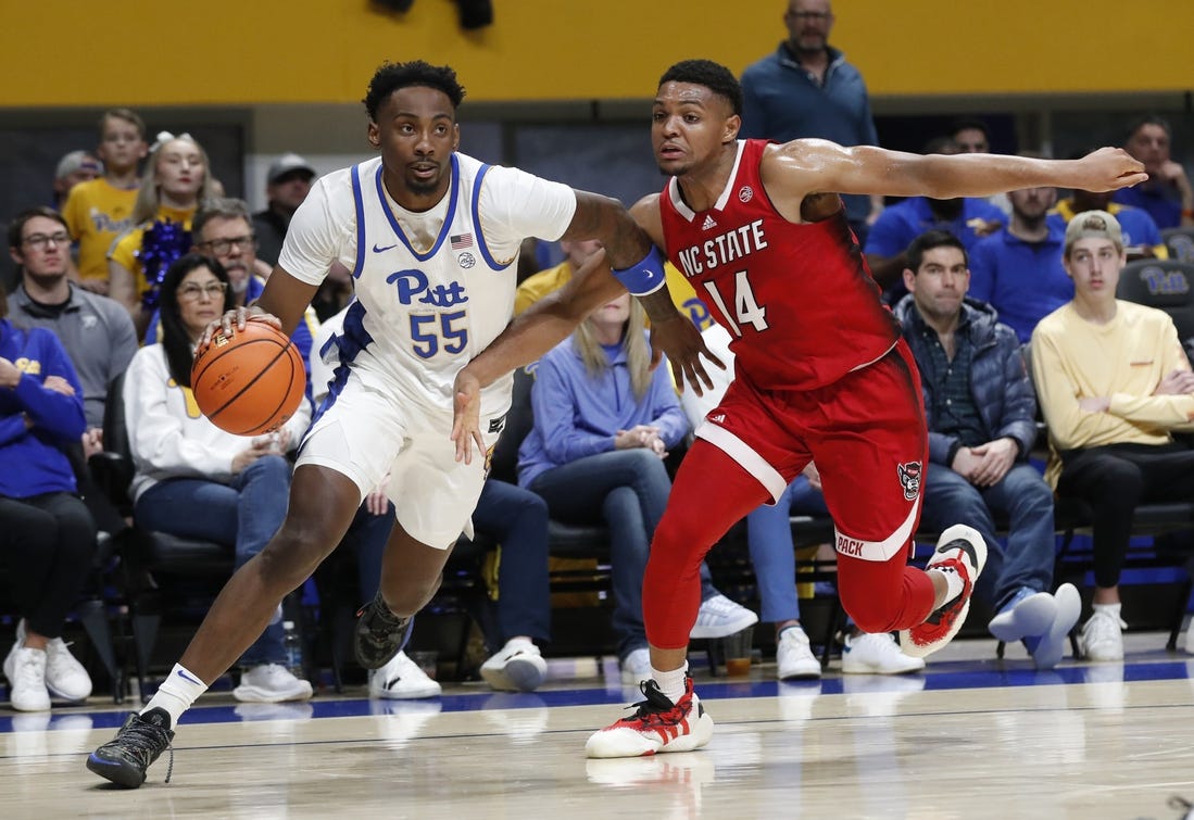 Mar 9, 2024; Pittsburgh, Pennsylvania, USA;  Pittsburgh Panthers forward Zack Austin (55) drives the baseline  against North Carolina State Wolfpack guard Casey Morsell (14) during the first half at the Petersen Events Center. Mandatory Credit: Charles LeClaire-USA TODAY Sports