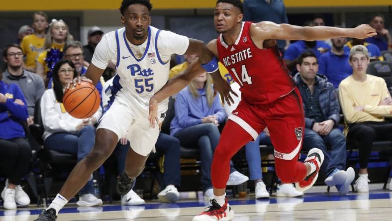 Mar 9, 2024; Pittsburgh, Pennsylvania, USA;  Pittsburgh Panthers forward Zack Austin (55) drives the baseline  against North Carolina State Wolfpack guard Casey Morsell (14) during the first half at the Petersen Events Center. Mandatory Credit: Charles LeClaire-USA TODAY Sports