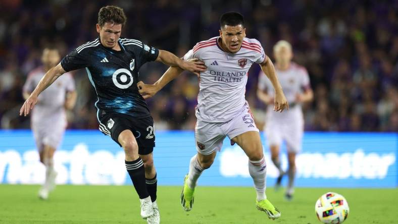 Mar 9, 2024; Orlando, Florida, USA; Orlando City midfielder Cesar Araujo (5) battles for the ball with Minnesota United midfielder Wil Trapp (20) during the first half at Inter & Co Stadium. Mandatory Credit: Nathan Ray Seebeck-USA TODAY Sports