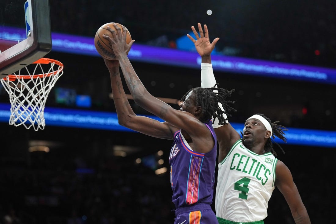 Mar 9, 2024; Phoenix, Arizona, USA; Phoenix Suns center Bol Bol (11) puts up a layup over Boston Celtics guard Jrue Holiday (4) during the first half at Footprint Center. Mandatory Credit: Joe Camporeale-USA TODAY Sports