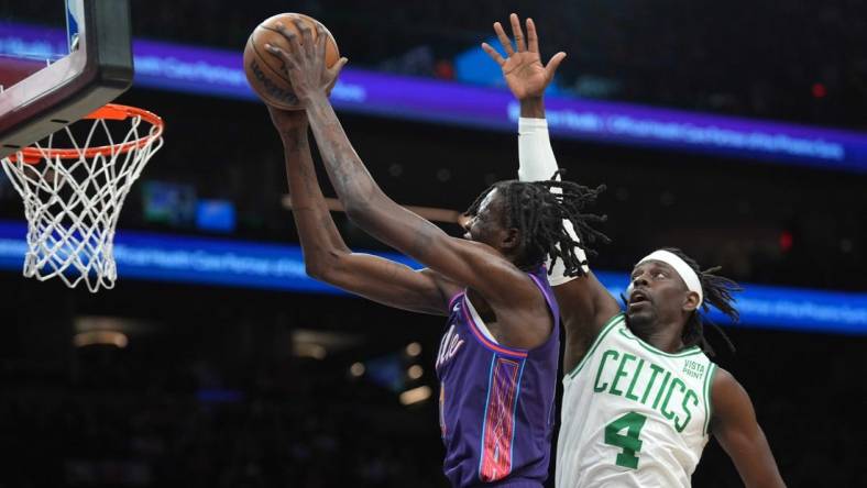 Mar 9, 2024; Phoenix, Arizona, USA; Phoenix Suns center Bol Bol (11) puts up a layup over Boston Celtics guard Jrue Holiday (4) during the first half at Footprint Center. Mandatory Credit: Joe Camporeale-USA TODAY Sports