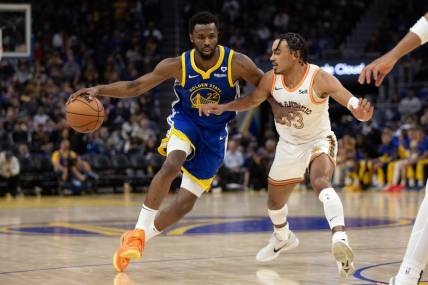 Mar 9, 2024; San Francisco, California, USA; Golden State Warriors forward Andrew Wiggins (22) tries to drive around San Antonio Spurs guard Tre Jones (33) during the second quarter at Chase Center. Mandatory Credit: D. Ross Cameron-USA TODAY Sports