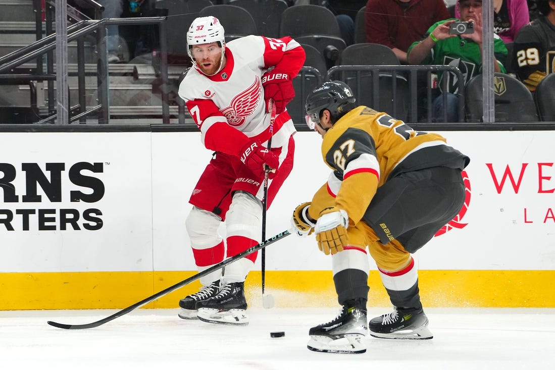 Mar 9, 2024; Las Vegas, Nevada, USA; Detroit Red Wings left wing J.T. Compher (37) makes a pass in front of Vegas Golden Knights defenseman Shea Theodore (27) during the first period at T-Mobile Arena. Mandatory Credit: Stephen R. Sylvanie-USA TODAY Sports