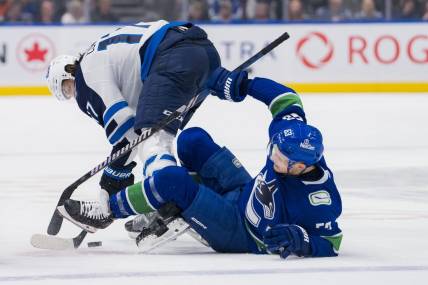 Mar 9, 2024; Vancouver, British Columbia, CAN; Winnipeg Jets forward Adam Lowry (17) checks Vancouver Canucks forward Teddy Blueger (53) in the first period at Rogers Arena. Mandatory Credit: Bob Frid-USA TODAY Sports