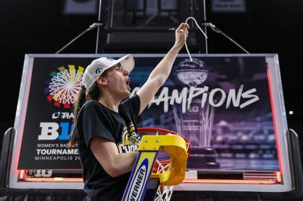 Mar 10, 2024; Minneapolis, MN, USA; Iowa Hawkeyes guard Caitlin Clark (22) cuts a piece off the net after the game against the Nebraska Cornhuskers at Target Center. Mandatory Credit: Matt Krohn-USA TODAY Sports