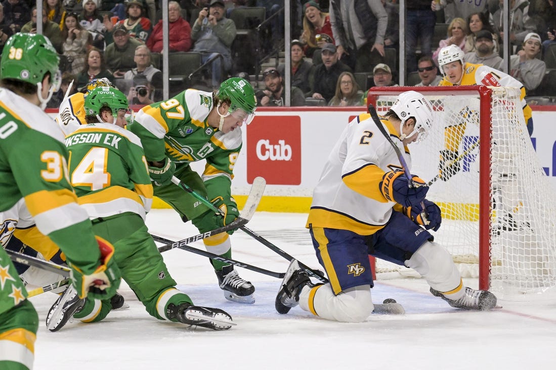 Mar 10, 2024; Saint Paul, Minnesota, USA;  Minnesota Wild forward Kirill Kaprizov (97) scores a power play goal as Nashville Predators defenseman Luke Schenn (2) looks for the puck during the second period at Xcel Energy Center. Mandatory Credit: Nick Wosika-USA TODAY Sports