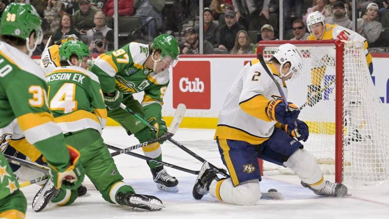 Mar 10, 2024; Saint Paul, Minnesota, USA;  Minnesota Wild forward Kirill Kaprizov (97) scores a power play goal as Nashville Predators defenseman Luke Schenn (2) looks for the puck during the second period at Xcel Energy Center. Mandatory Credit: Nick Wosika-USA TODAY Sports