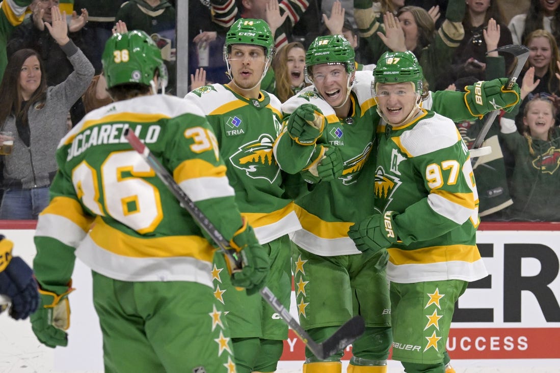 Mar 10, 2024; Saint Paul, Minnesota, USA;  Minnesota Wild forward Matt Boldy (12) points to forward Mats Zuccarello (36) who assisted on his overtime game-winning goal against the Nashville Predators as he celebrates with forward Joel Eriksson Ek (14) and forward Kirill Kaprizov (97) at Xcel Energy Center. Mandatory Credit: Nick Wosika-USA TODAY Sports