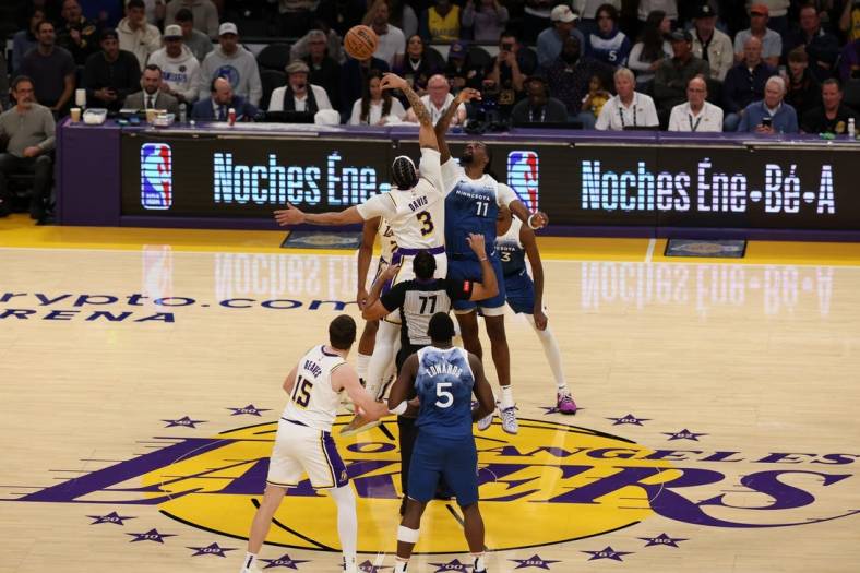 Mar 10, 2024; Los Angeles, California, USA;  Los Angeles Lakers forward Anthony Davis (3) and Minnesota Timberwolves center Naz Reid (11) tip off during the first quarter at Crypto.com Arena. Mandatory Credit: Kiyoshi Mio-USA TODAY Sports