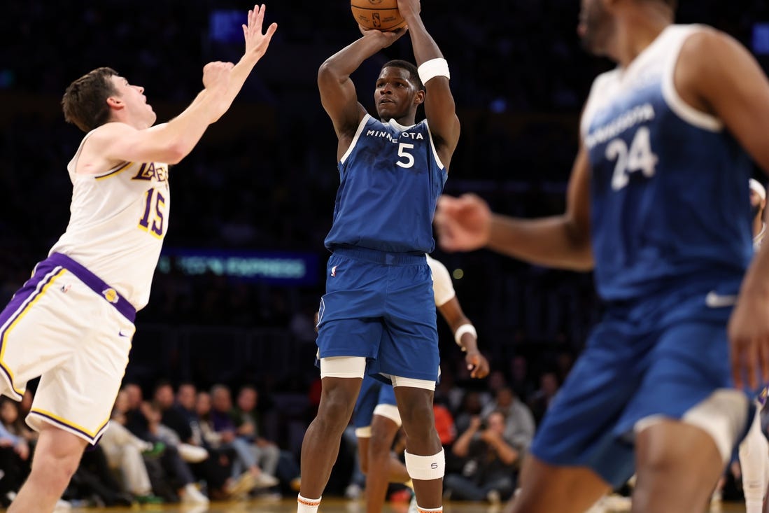 Mar 10, 2024; Los Angeles, California, USA;  Minnesota Timberwolves guard Anthony Edwards (5) shoots the ball over Los Angeles Lakers guard Austin Reaves (15) during the fourth quarter at Crypto.com Arena. Mandatory Credit: Kiyoshi Mio-USA TODAY Sports