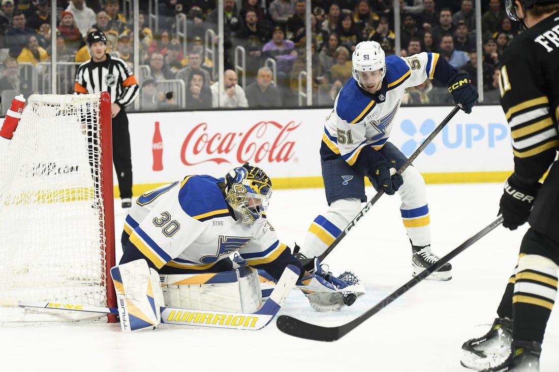 Mar 11, 2024; Boston, Massachusetts, USA;  St. Louis Blues goaltender Joel Hofer (30) gathers the puck in front of St. Louis Blues defenseman Matthew Kessel (51) during the first period against the Boston Bruins at TD Garden. Mandatory Credit: Bob DeChiara-USA TODAY Sports