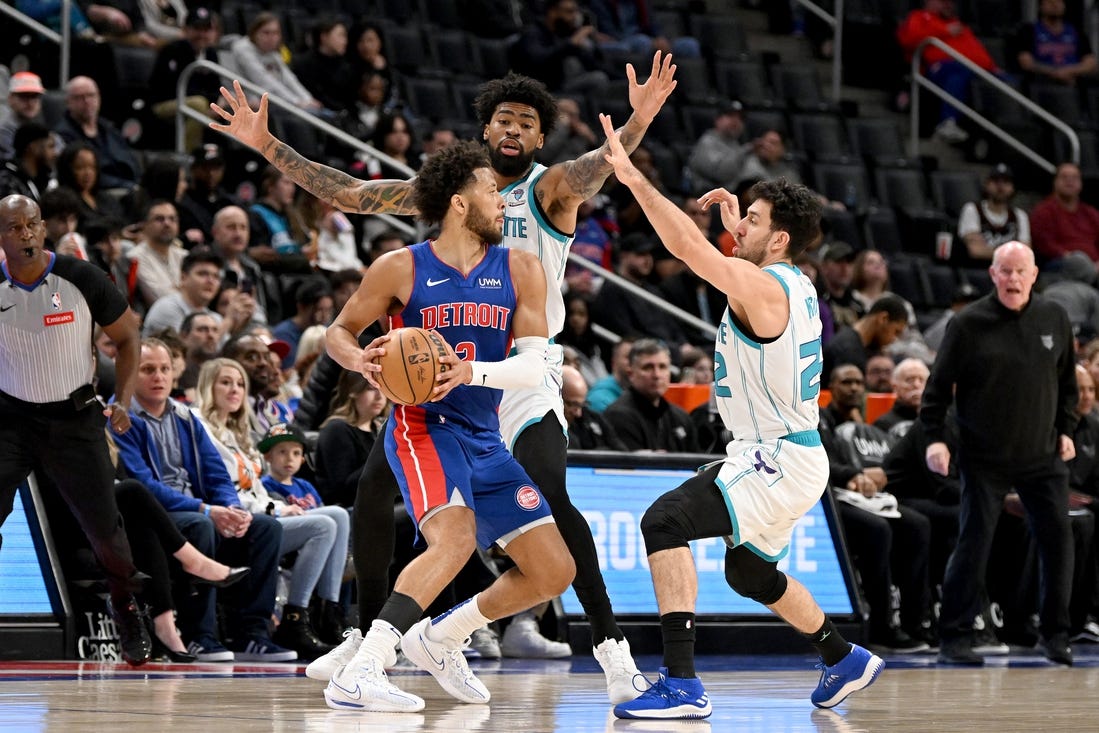 Mar 11, 2024; Detroit, Michigan, USA;   Detroit Pistons guard Cade Cunningham (2) is double teamed by Charlotte Hornets guard Vasilije Micic (22) and center Nick Richards (4) in the first quarter at Little Caesars Arena. Mandatory Credit: Lon Horwedel-USA TODAY Sports