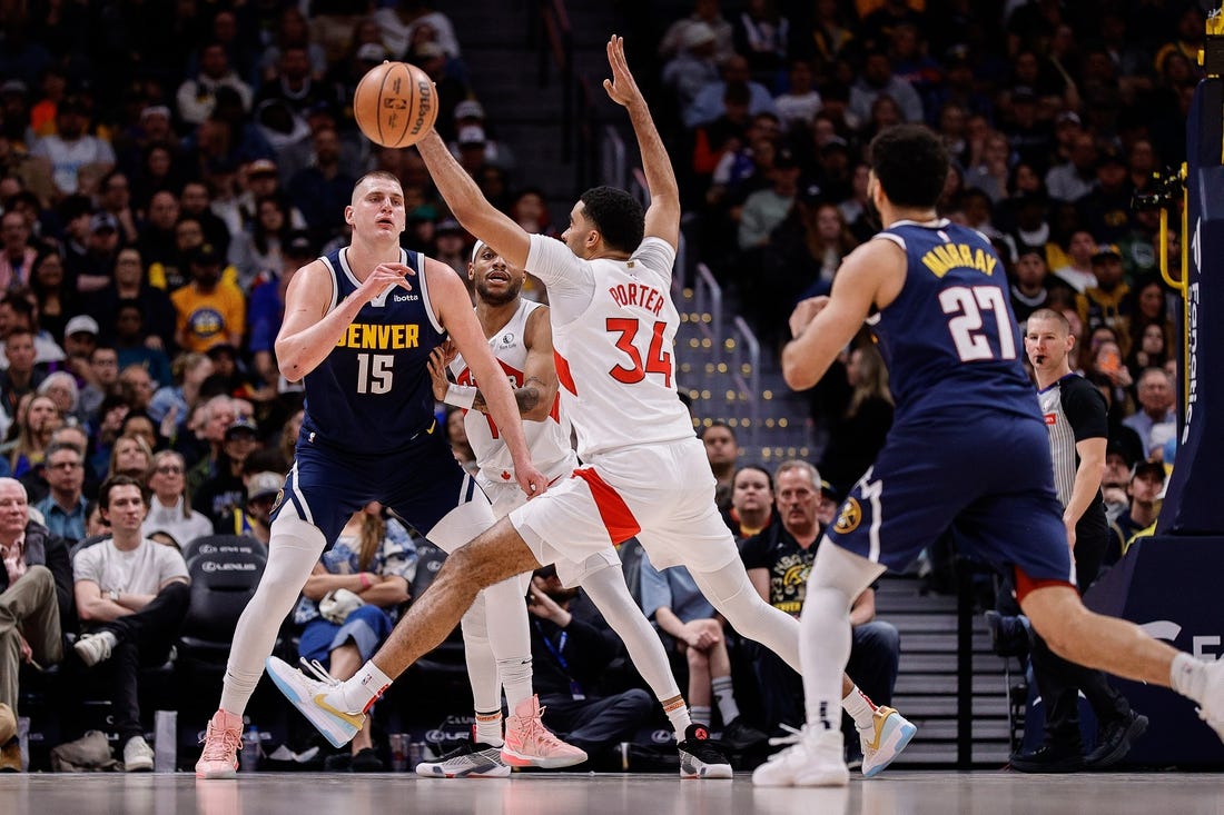 Mar 11, 2024; Denver, Colorado, USA; Denver Nuggets center Nikola Jokic (15) passes the ball to guard Jamal Murray (27) as Toronto Raptors forward Bruce Brown (11) and center Jontay Porter (34) defend in the second quarter at Ball Arena. Mandatory Credit: Isaiah J. Downing-USA TODAY Sports