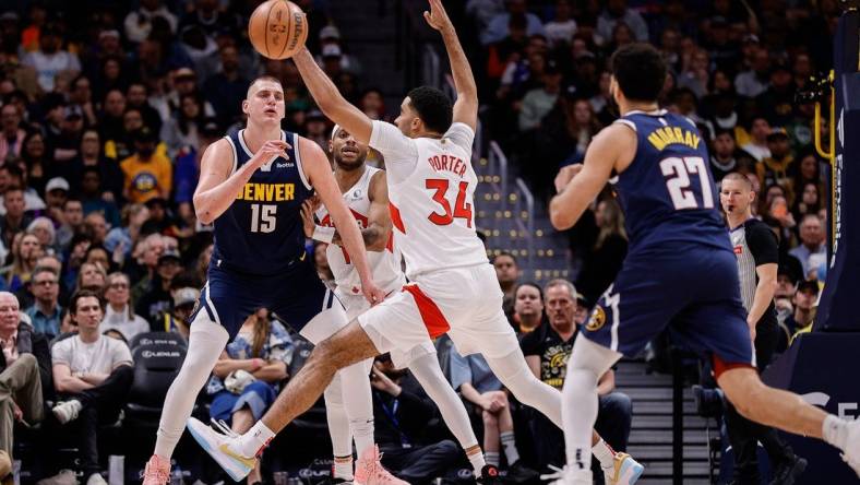 Mar 11, 2024; Denver, Colorado, USA; Denver Nuggets center Nikola Jokic (15) passes the ball to guard Jamal Murray (27) as Toronto Raptors forward Bruce Brown (11) and center Jontay Porter (34) defend in the second quarter at Ball Arena. Mandatory Credit: Isaiah J. Downing-USA TODAY Sports