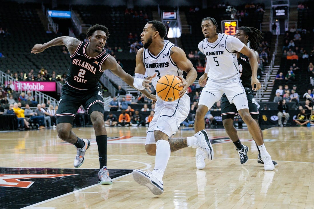 Mar 12, 2024; Kansas City, MO, USA; UCF Knights guard Darius Johnson (3) drives to the basket around Oklahoma State Cowboys forward Eric Dailey Jr. (2) during the first half at T-Mobile Center. Mandatory Credit: William Purnell-USA TODAY Sports