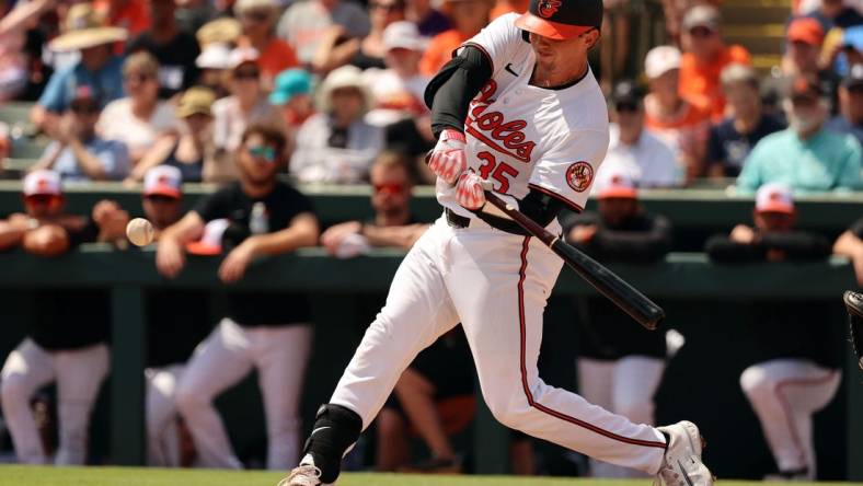 Mar 12, 2024; Sarasota, Florida, USA; Baltimore Orioles catcher Adley Rutschman (35) hits a RBI single during the second inning against the Tampa Bay Rays at Ed Smith Stadium. Mandatory Credit: Kim Klement Neitzel-USA TODAY Sports