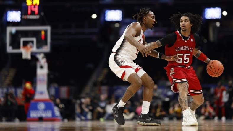 Mar 12, 2024; Washington, D.C., USA; Louisville Cardinals guard Skyy Clark (55) drives to the basket as North Carolina State Wolfpack guard Jayden Taylor (1) defends in the first half at Capital One Arena. Mandatory Credit: Geoff Burke-USA TODAY Sports