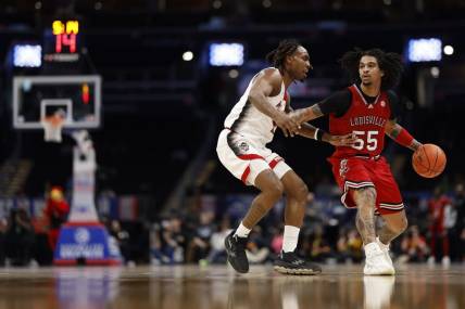 Mar 12, 2024; Washington, D.C., USA; Louisville Cardinals guard Skyy Clark (55) drives to the basket as North Carolina State Wolfpack guard Jayden Taylor (1) defends in the first half at Capital One Arena. Mandatory Credit: Geoff Burke-USA TODAY Sports