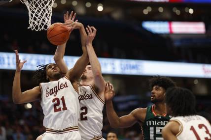 Mar 12, 2024; Washington, D.C., USA; Boston College Eagles forward Devin McGlockton (21) and College Eagles forward Quinten Post (12) reach for a rebound in front of Miami (Fl) Hurricanes forward Norchad Omier (15) in the first half at Capital One Arena. Mandatory Credit: Geoff Burke-USA TODAY Sports