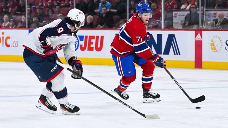 Mar 12, 2024; Montreal, Quebec, CAN; Montreal Canadiens center Jake Evans (71) plays the puck against Columbus Blue Jackets defenseman Ivan Provorov (9) during the first period at Bell Centre. Mandatory Credit: David Kirouac-USA TODAY Sports