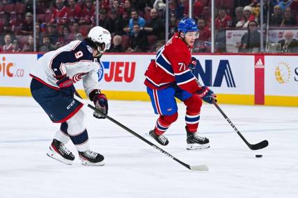 Mar 12, 2024; Montreal, Quebec, CAN; Montreal Canadiens center Jake Evans (71) plays the puck against Columbus Blue Jackets defenseman Ivan Provorov (9) during the first period at Bell Centre. Mandatory Credit: David Kirouac-USA TODAY Sports