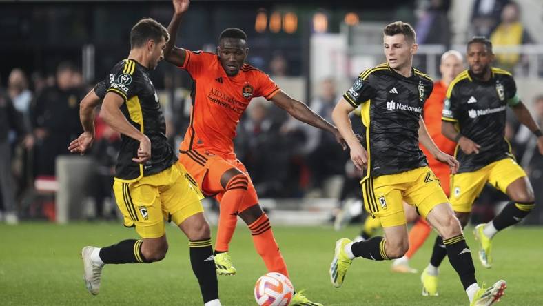 Mar 12, 2024; Columbus, OH, USA;  Columbus Crew defender Yevhen Cheberko (21) kicks the ball from Houston Dynamo forward Ibrahim Aliyu (18) during the second half of the Concacaf Champions Cup soccer game at Lower.com Field. Mandatory Credit: Adam Cairns-USA TODAY Sports