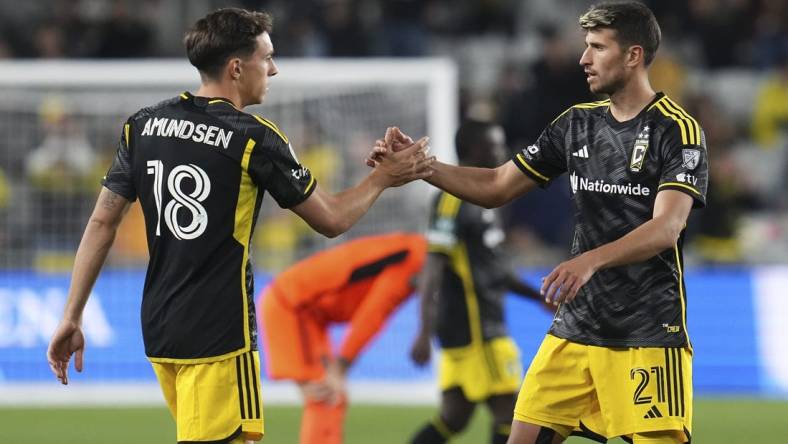 Mar 12, 2024; Columbus, OH, USA;  Columbus Crew defender Malte Amundsen (18) celebrates the win with defender Yevhen Cheberko (21) following the Concacaf Champions Cup soccer game against the Houston Dynamo at Lower.com Field. Mandatory Credit: Adam Cairns-USA TODAY Sports