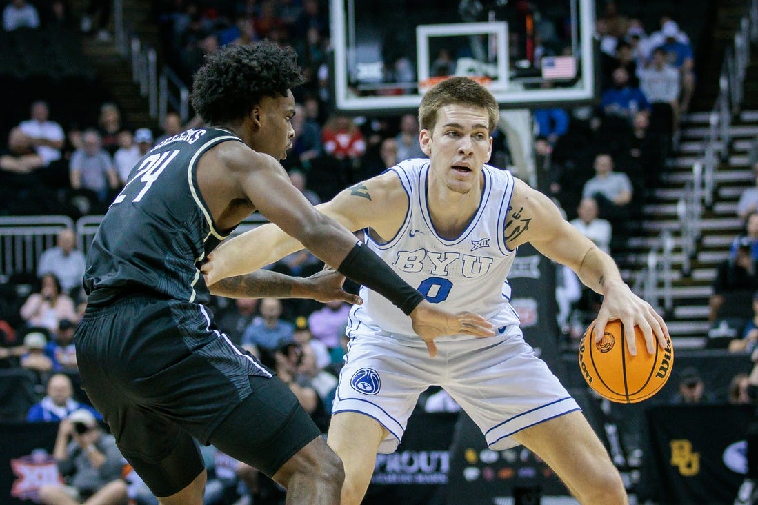 Mar 13, 2024; Kansas City, MO, USA; Brigham Young Cougars forward Noah Waterman (0) brings the ball up court around UCF Knights guard Jaylin Sellers (24) during the first half at T-Mobile Center. Mandatory Credit: William Purnell-USA TODAY Sports