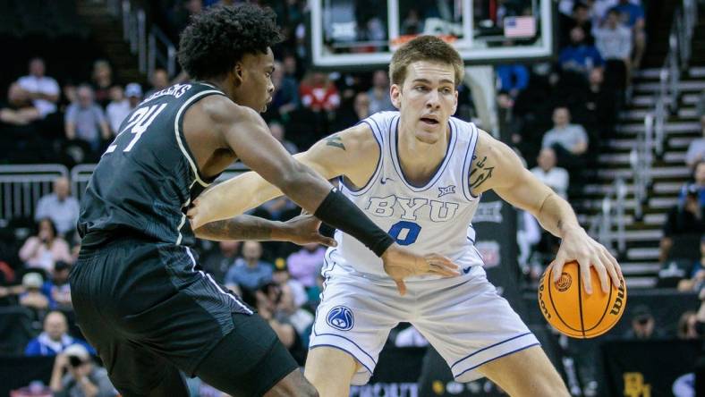 Mar 13, 2024; Kansas City, MO, USA; Brigham Young Cougars forward Noah Waterman (0) brings the ball up court around UCF Knights guard Jaylin Sellers (24) during the first half at T-Mobile Center. Mandatory Credit: William Purnell-USA TODAY Sports