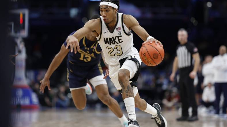 Mar 13, 2024; Washington, D.C., USA; Wake Forest Demon Deacons guard Hunter Sallis (23) drives to the basket past Notre Dame Fighting Irish forward Tae Davis (13) in the second half at Capital One Arena. Mandatory Credit: Geoff Burke-USA TODAY Sports