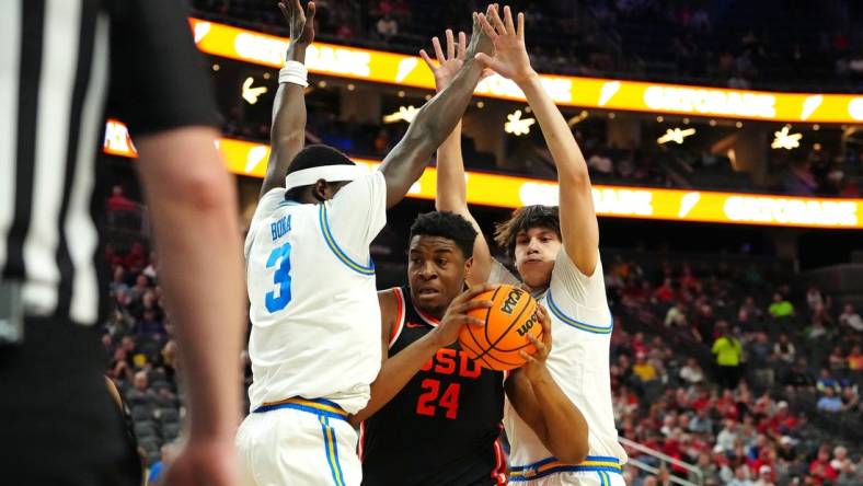 Mar 13, 2024; Las Vegas, NV, USA; Oregon State Beavers center KC Ibekwe (24) looks to shoot between UCLA Bruins forward Adem Bona (3) and UCLA Bruins forward Berke Buyuktuncel (9) during the first half at T-Mobile Arena. Mandatory Credit: Stephen R. Sylvanie-USA TODAY Sports