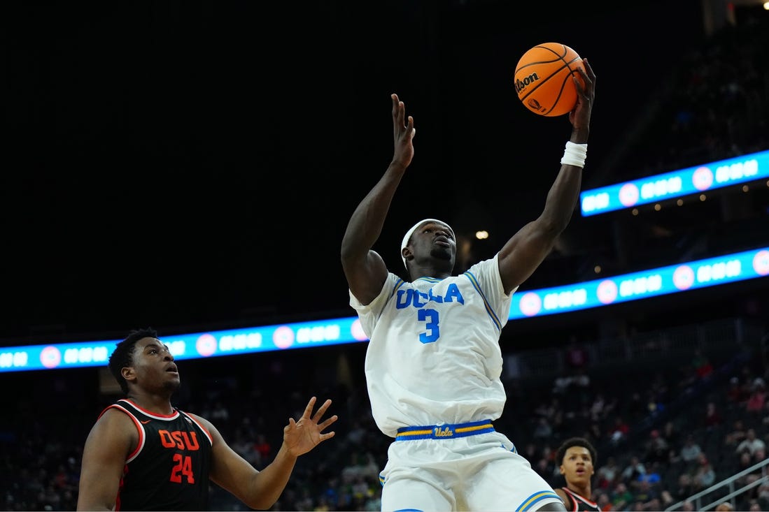 Mar 13, 2024; Las Vegas, NV, USA; UCLA Bruins forward Adem Bona (3) catches the ball against Oregon State Beavers center KC Ibekwe (24) in the first half at T-Mobile Arena. Mandatory Credit: Kirby Lee-USA TODAY Sports